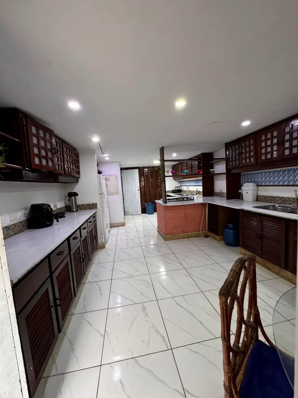 Cozinha ampla com fogão a gás e bancada extensa, preparada para grandes grupos