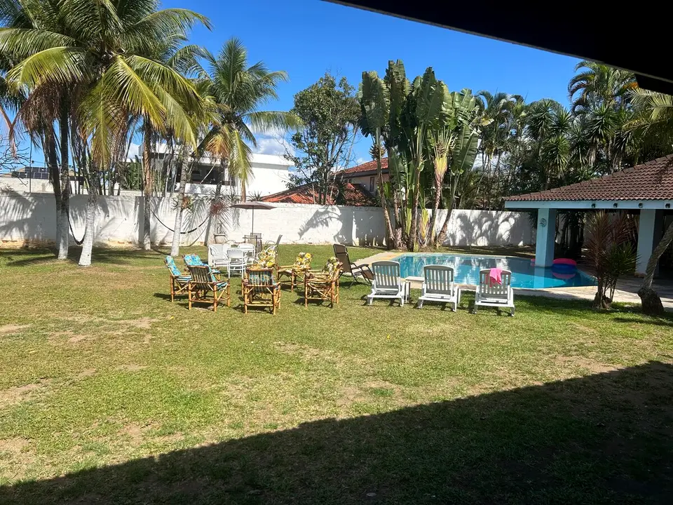 Amplo gramado do jardim cercado por palmeiras e vegetação tropical