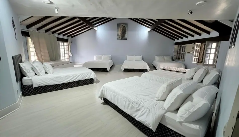 Quarto 6 da mansão, com múltiplas camas de casal e de solteiro